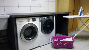 Buanderie pour les appartements avec lave linge et sèche linge.