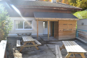 Terrasse aménagée avec tables et barbecue à gaz.